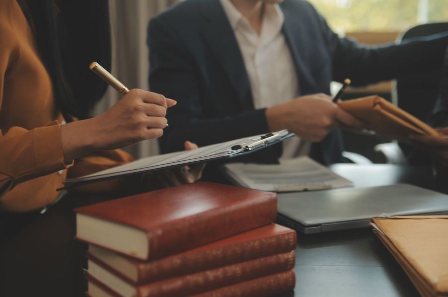 Image of lawyers signing documents in a meeting