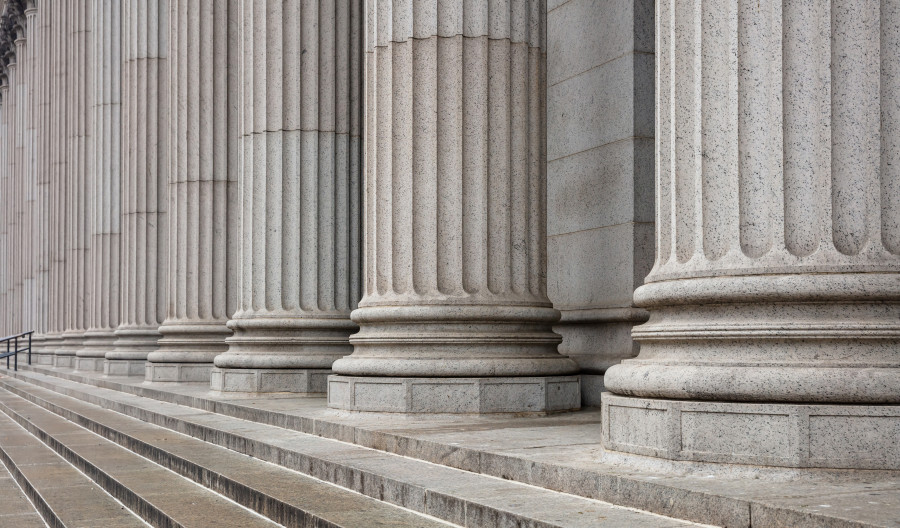 Stone pillars from a low angle, denoting a court building.