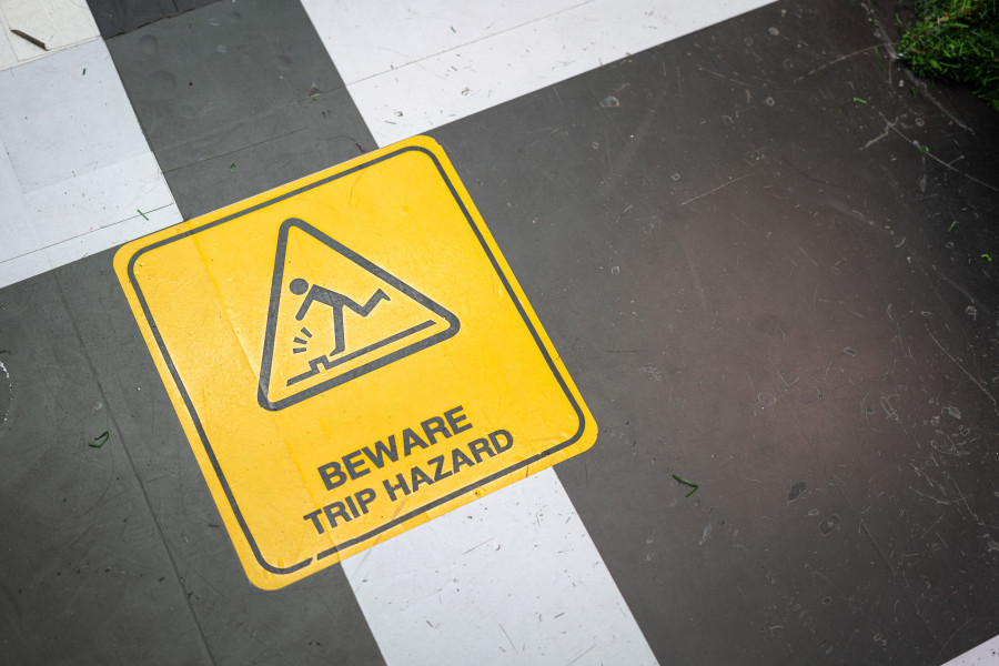 A yellow 'Beware: Trip Hazard" sign on the ground.