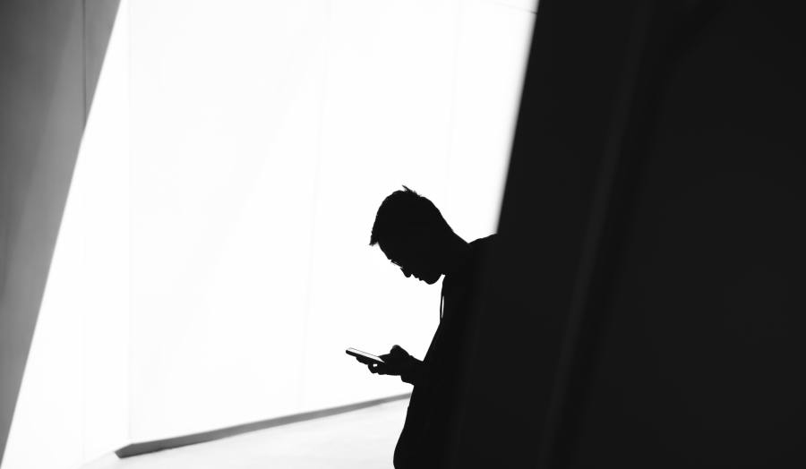 Person in profile using a mobile phone.