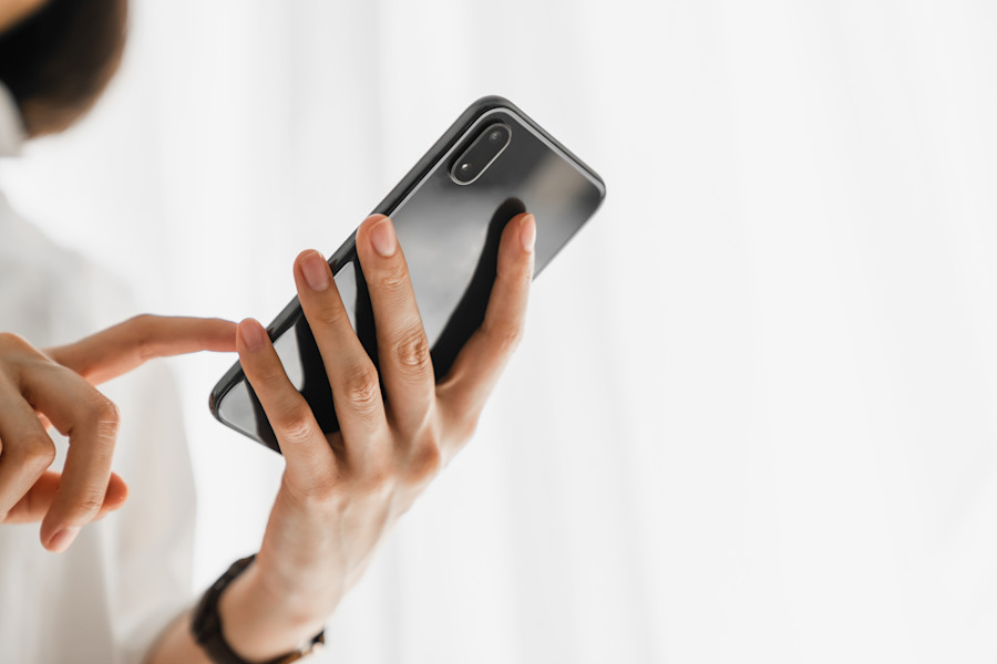 Close-up of woman's hand as she uses her mobile phone.