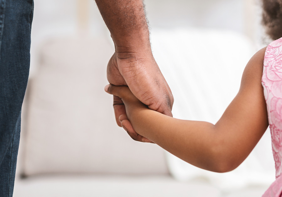 little girl holding an adults hand. 