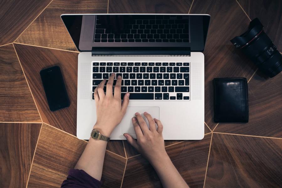 An overhead shot of a person typing on a laptop. 