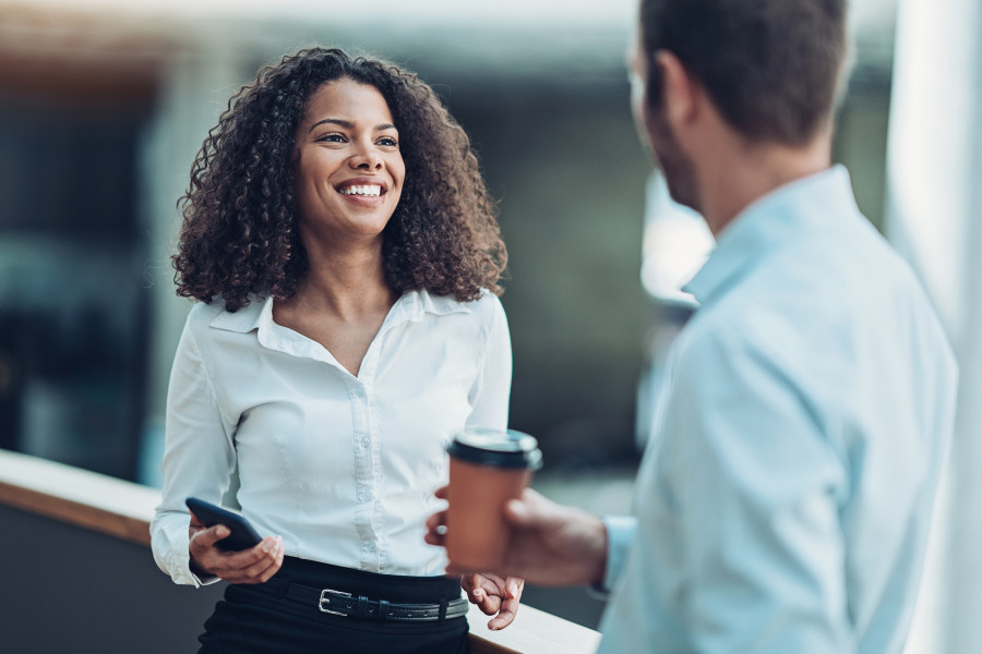 Corporate woman and man in an office having a conversation.