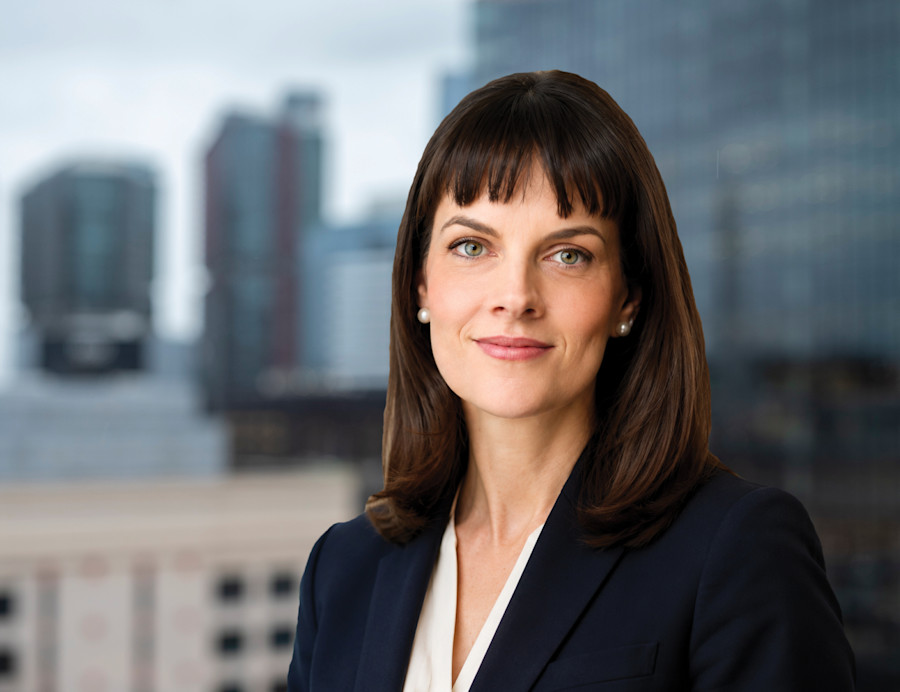 Charlotte Symes professional profile photograph with a cityscape background. 