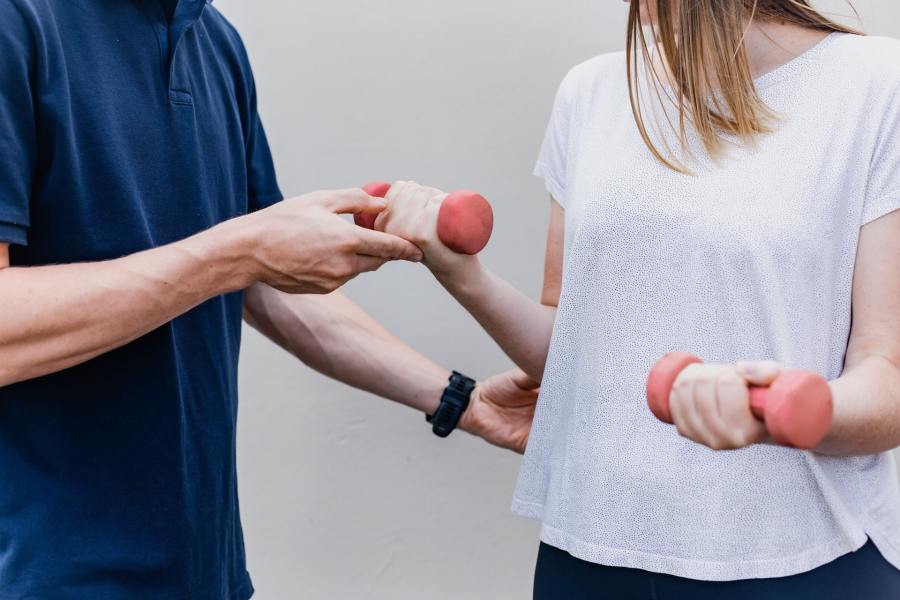A physiotherapist or chiropractor treating a patient with the use of hand weights. 
