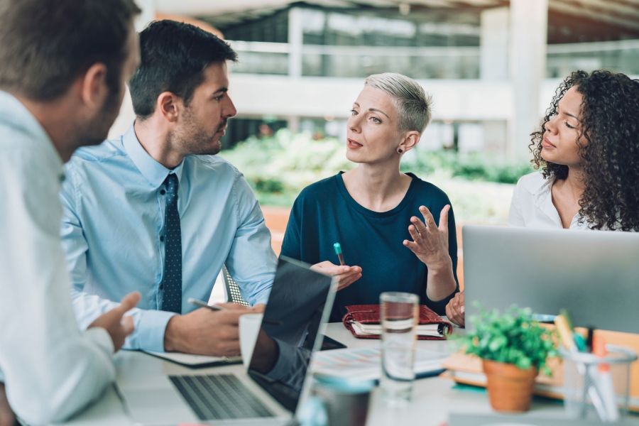 A group of corporate employees having a discussion around a table.