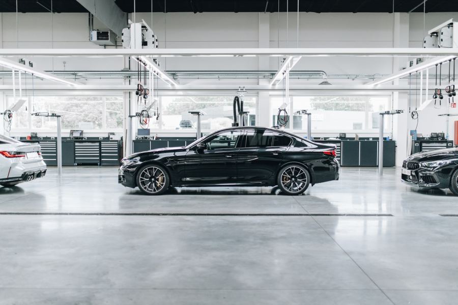 A black sedan car on a production line at a manufacturing facility or showroom. 