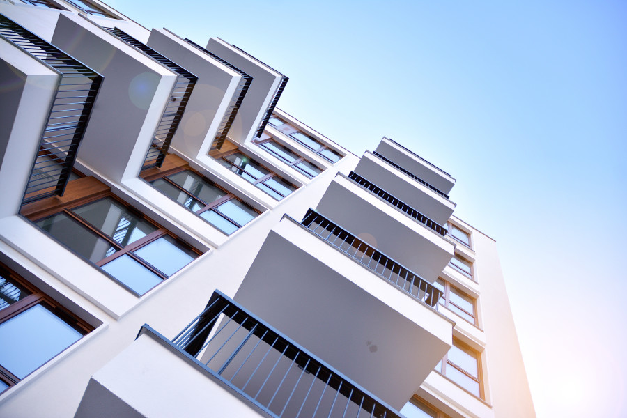 Residential apartment building pictured against a blue sky.