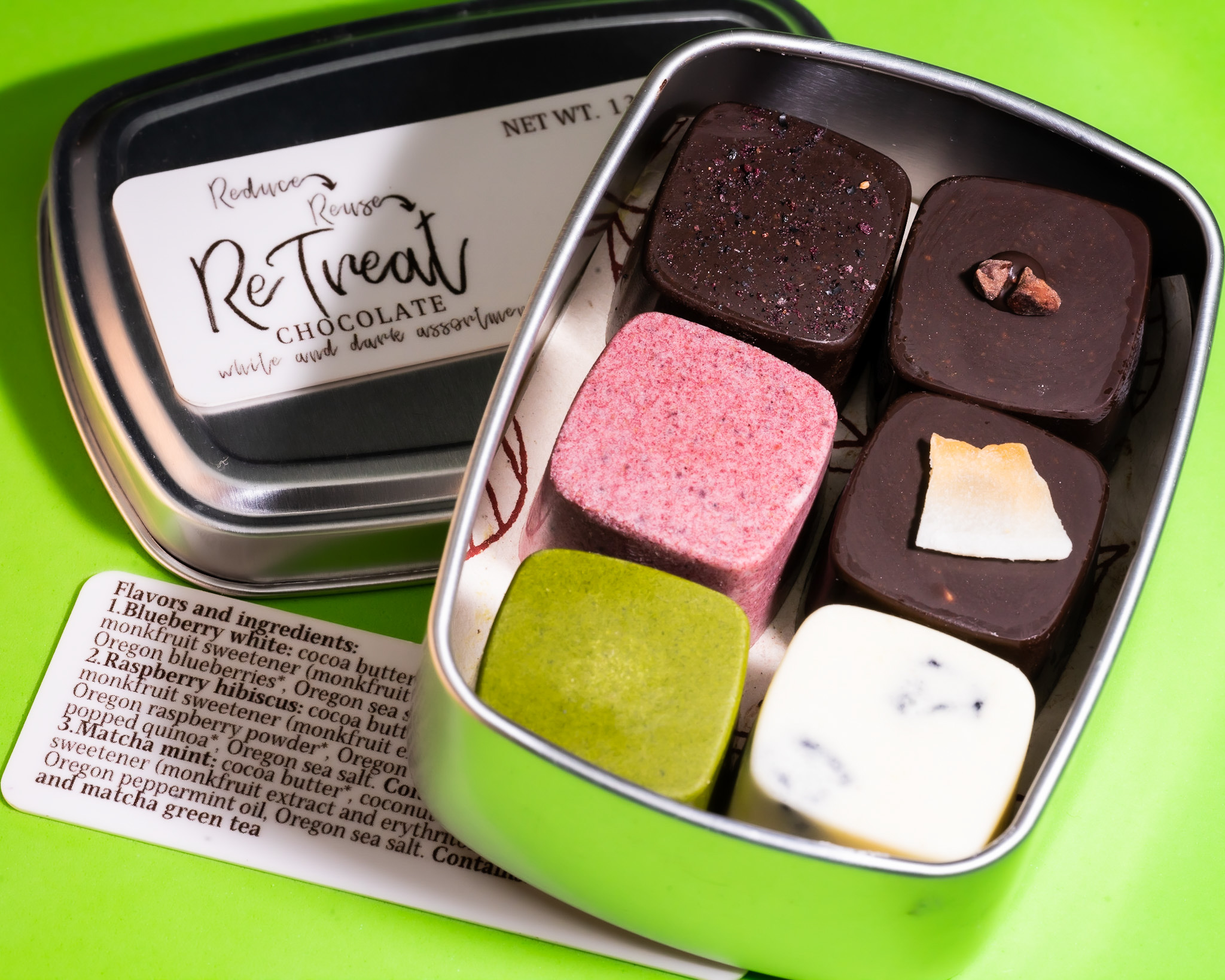 a small tin containing six cubic chocolate treats