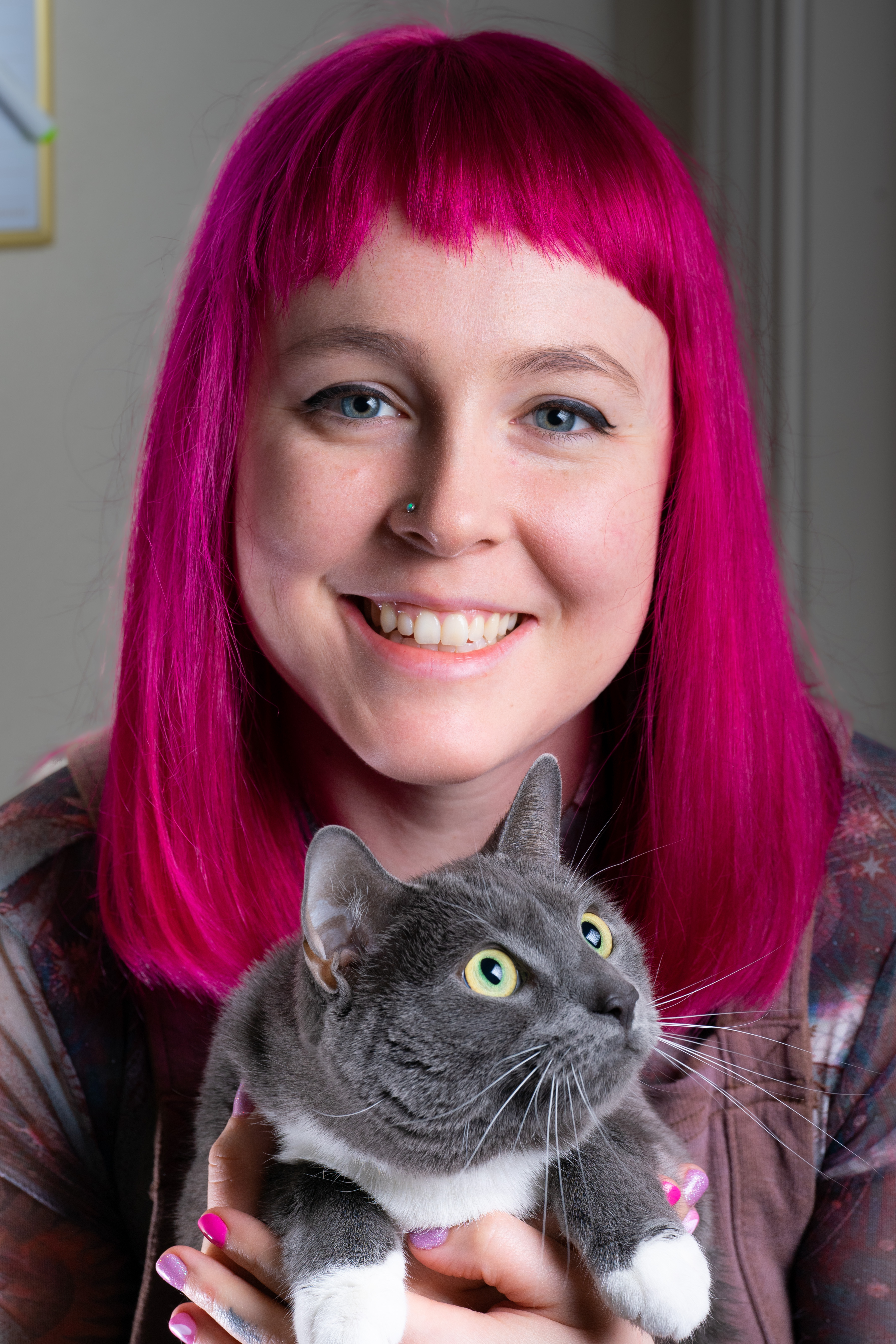 A pink haired lady and a grey haired cat