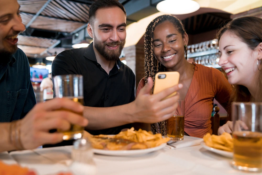 group-of-friends-using-a-mobile-phone-at-a-restaur