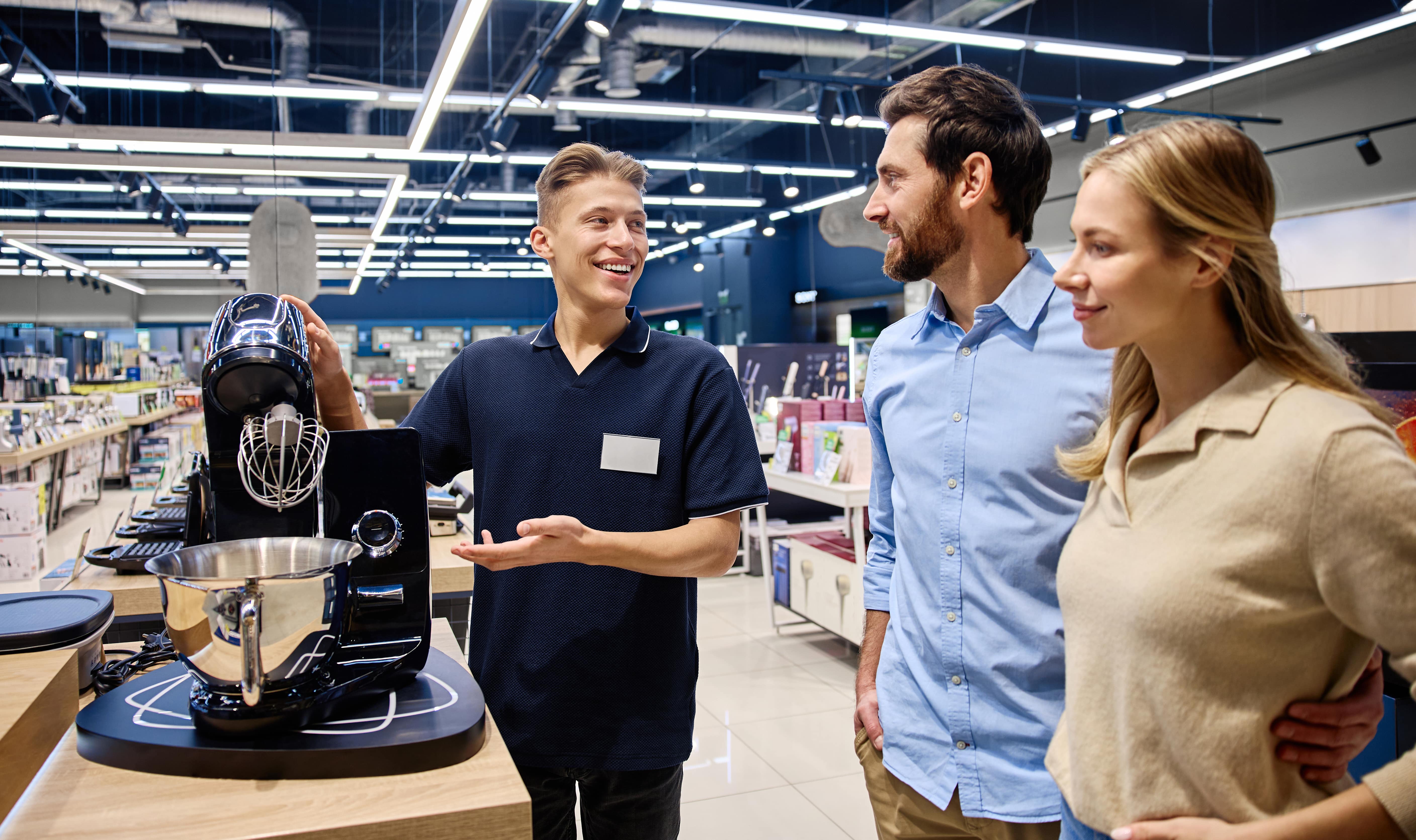 a-sales-associate-showcases-a-kitchen-appliance-to-2025-03-24-08-12-12-utc-min