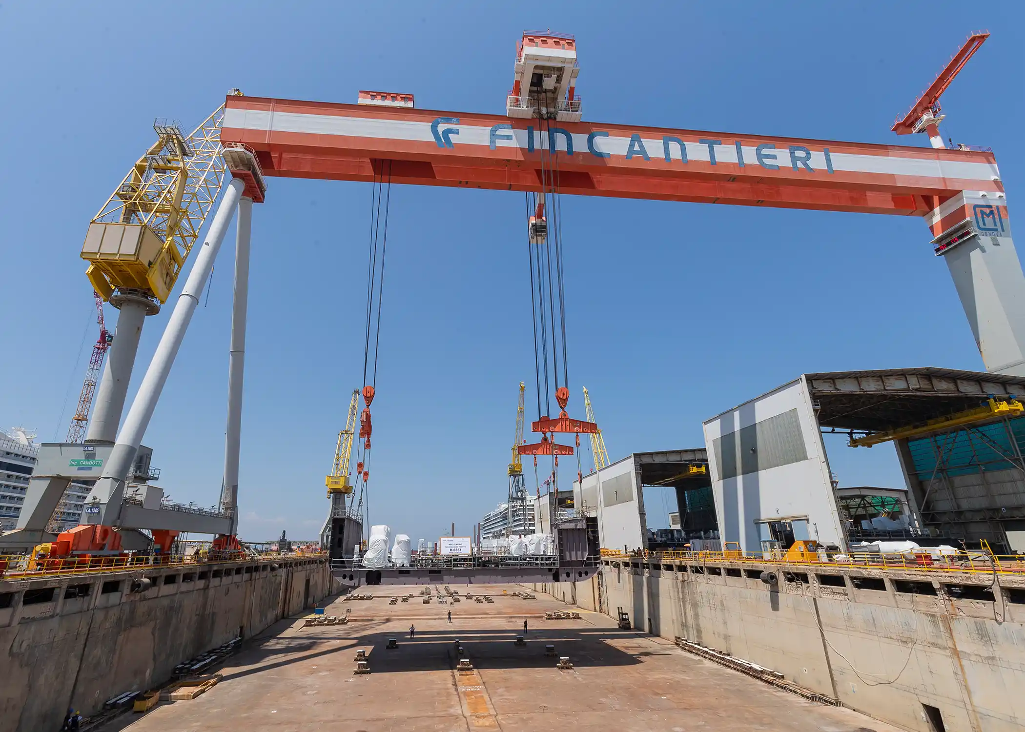 At the Fincantieri shipyard in Italy, a crane moves the keel to the dry dock, where construction will begin.