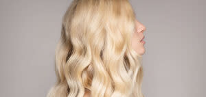 Junge Frau mit langen blonden gelockten Remy Echthaar Extensions