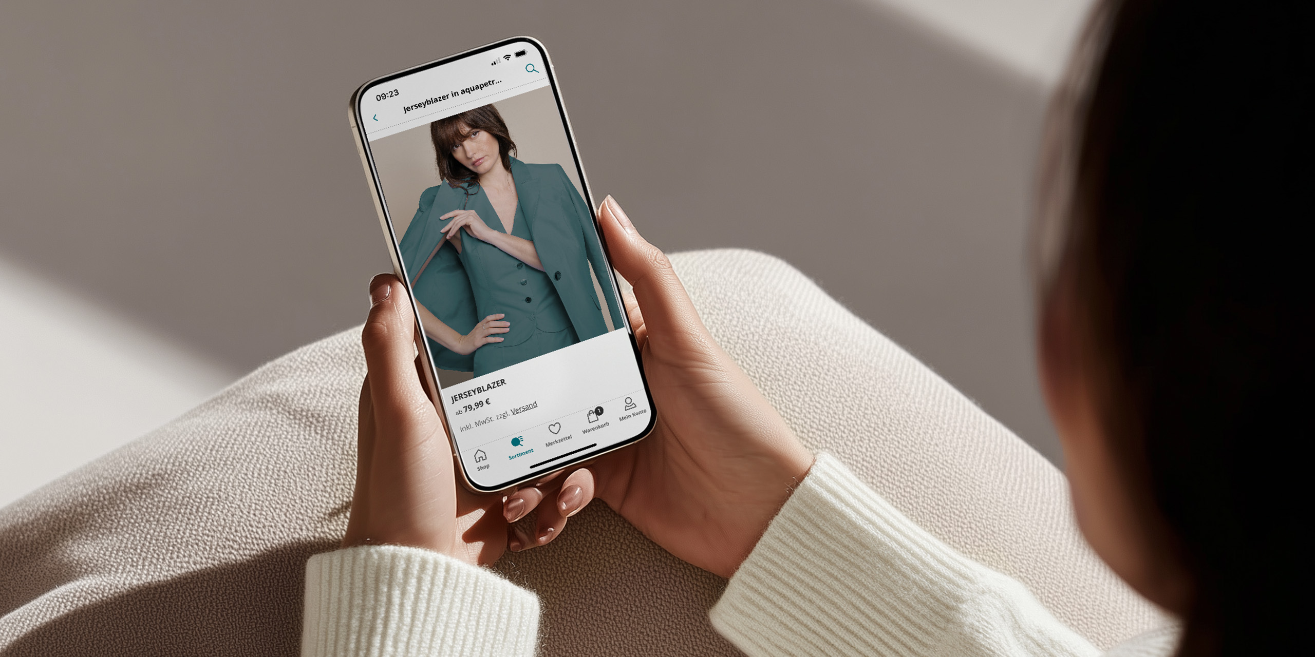 Model hält Handy in der Hand.