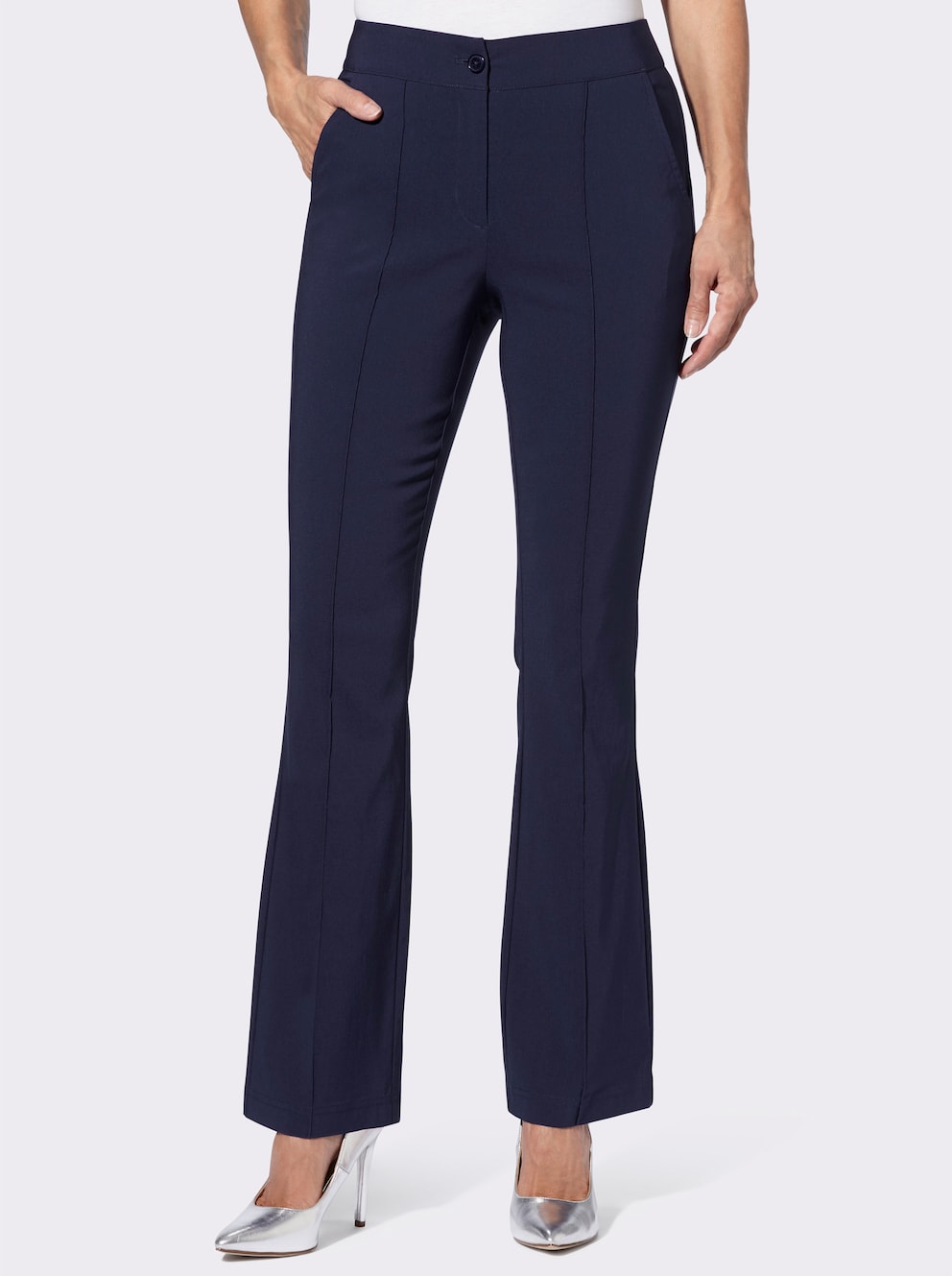 Model trägt eine dunkelblaue Hose und silberne Pumps. 