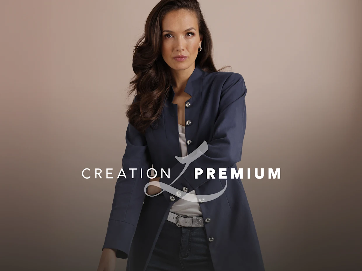 Ein Model mit hellblauem Glitzer-Shirt und heller Hose vor blauem Hintergrund. Im Vordergrund steht 'CREATION L PREMIUM'