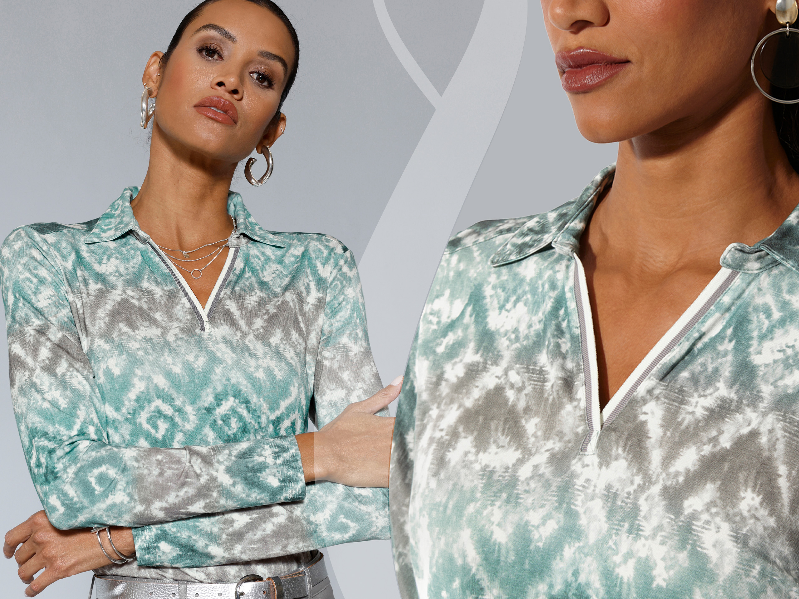 Ein Model trägt eine langärmlige Bluse mit grün-grauem Muster und V-Ausschnitt, dazu große Creolen und Schmuck.