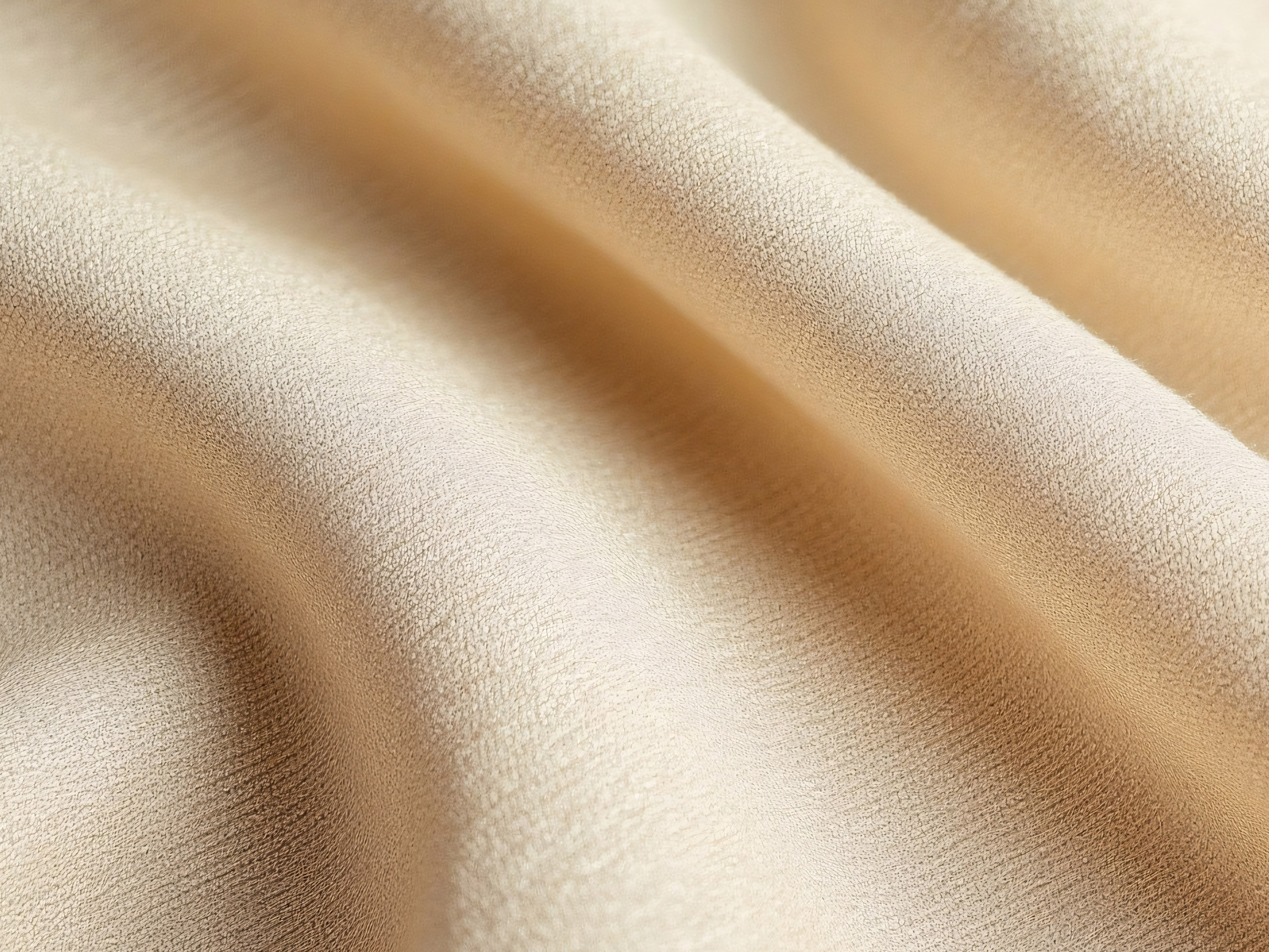 Weicher, beiger Stoff mit geschwungenen Falten.
