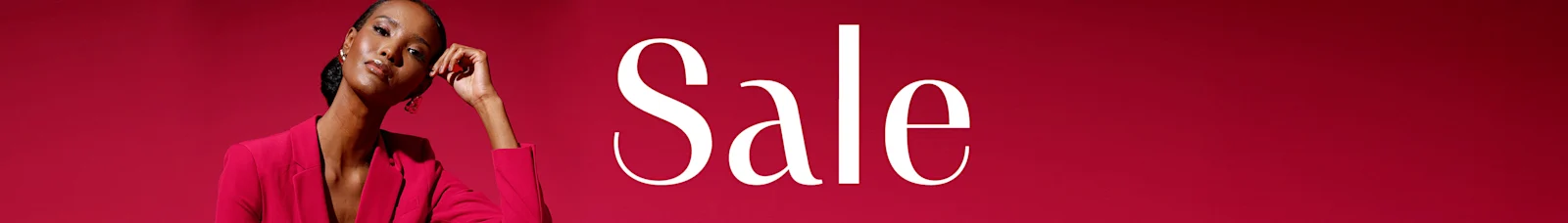 Ein Model sitzt in einem roten Anzug vor rotem Hintergrund, daneben steht groß das Wort 'Sale' in weißer Schrift.