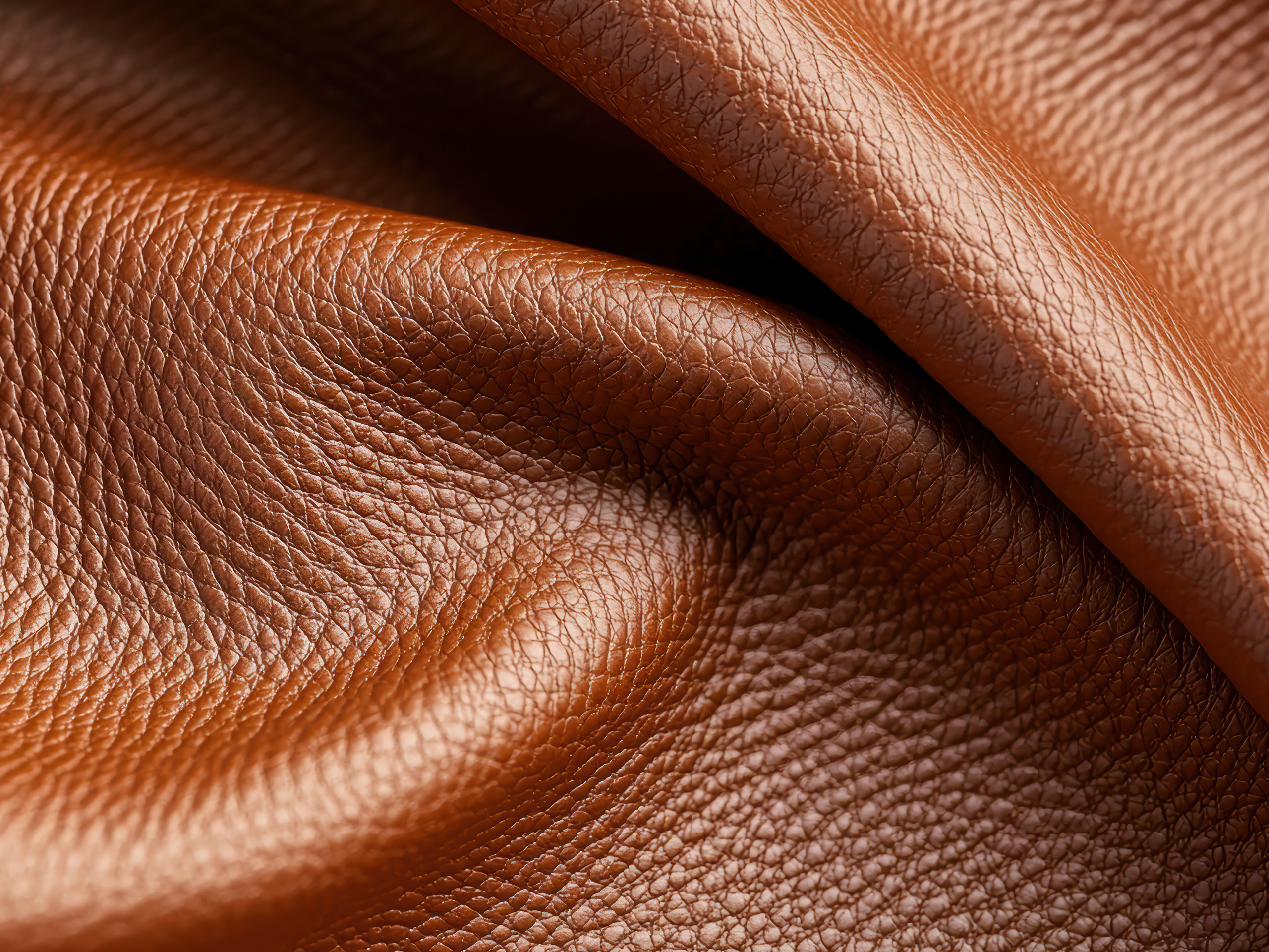 Nahaufnahme von beigem Leder mit sichtbarer Naht.