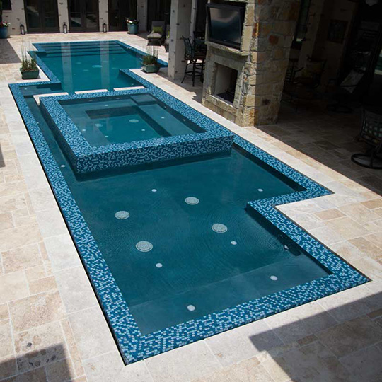 A large swimming pool with a fireplace in the background