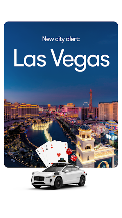 A white Waymo SUV in front of the Las Vegas skyline. 