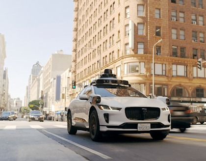 Waymo vehicle driving on busy city street
