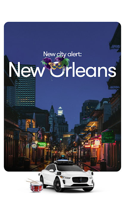 A white, Waymo I-PACE with a drum driving down Bourbon Street in New Orleans.