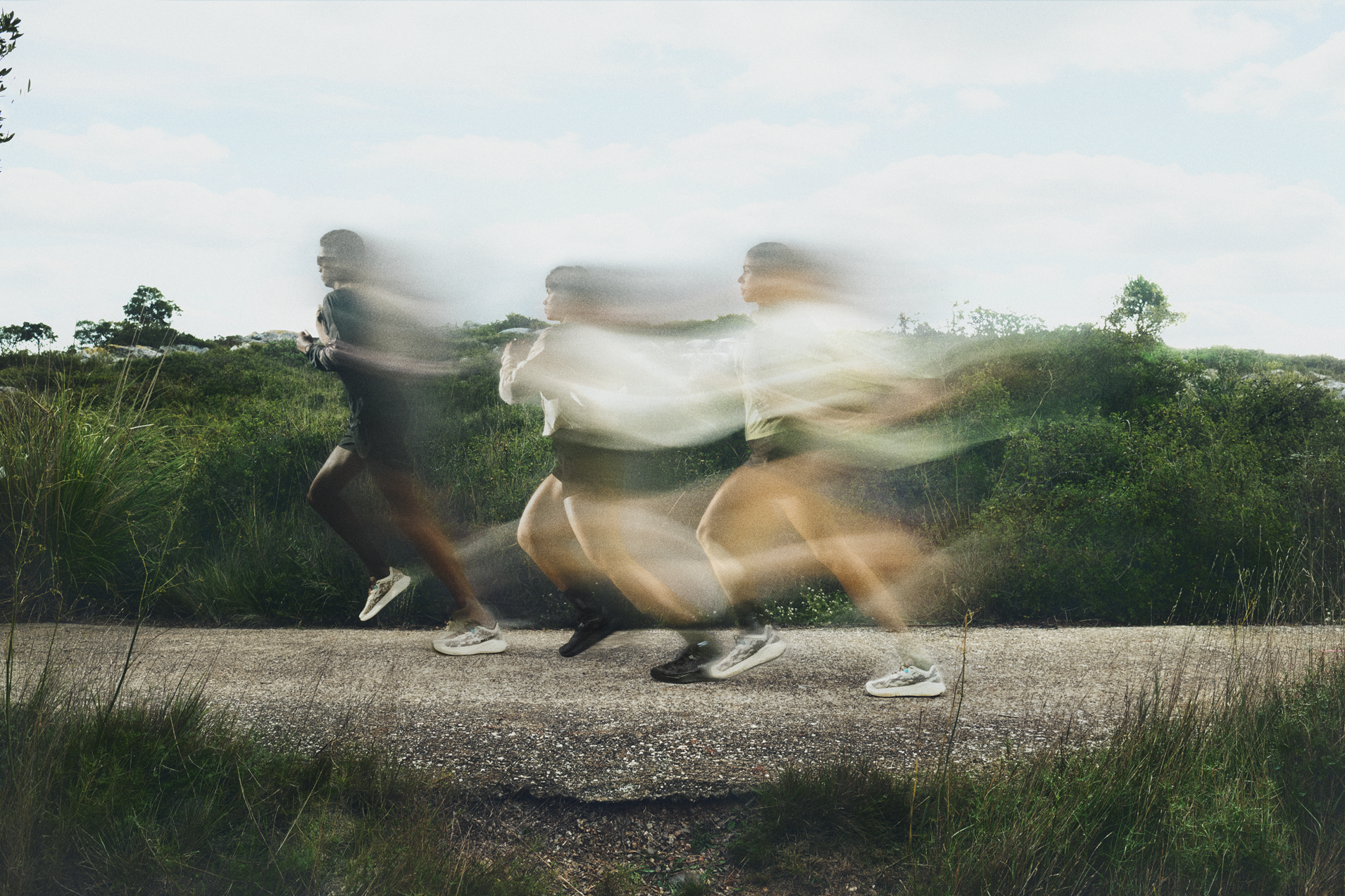 Sur un parcours de gravel running, trois coureurs avancent avec un effet de flou de mouvement.