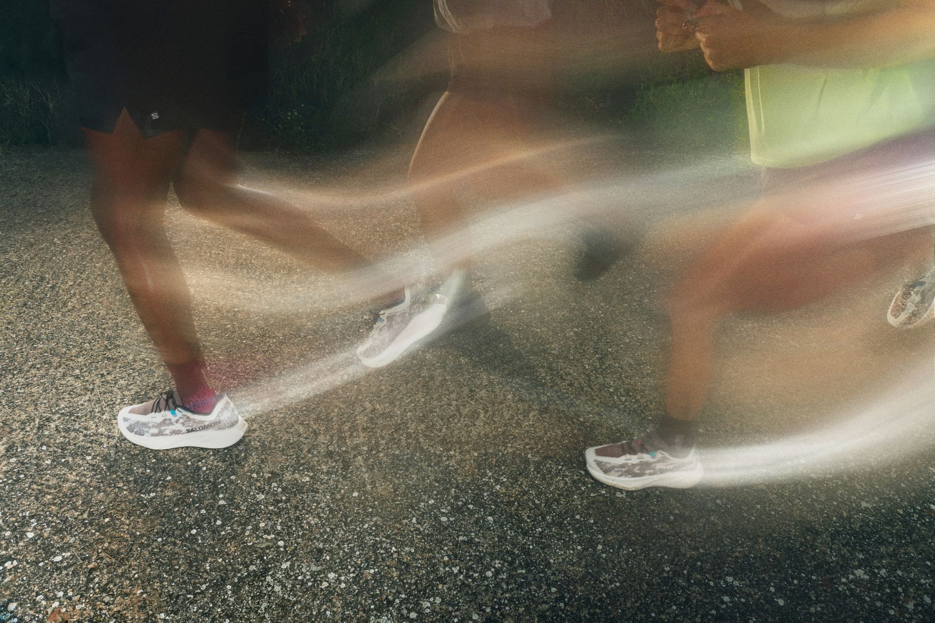 Primer plano de corredores de gravel running mostrando la activación muscular de la parte inferior del cuerpo con la silueta de una ciudad de fondo.