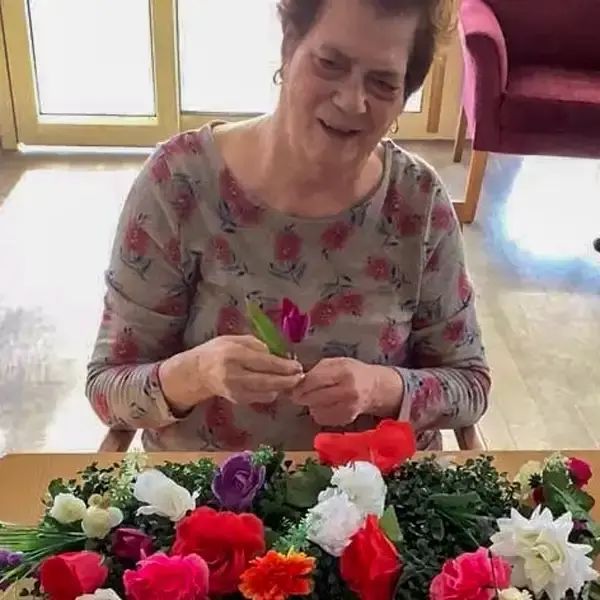 Franca Bupa South Morang resident arranging flowers in a green wall