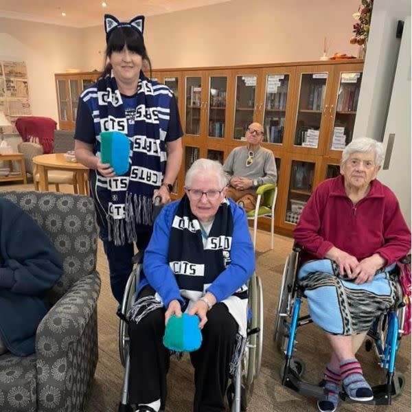 Aged care home Barrabool team member with residents cheering on their football Geelong cats team