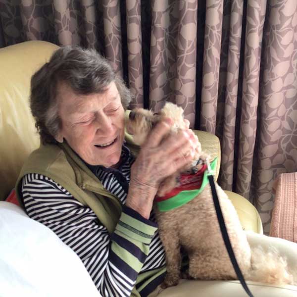Bupa Runaway Bay resident Jill enjoying cuddle time with therapy dog Benji