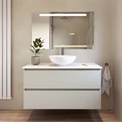 Moderne badkamermeubel met witte waskom, verlichte spiegel en kleine groene plant in een lichte, minimalistische badkamer.