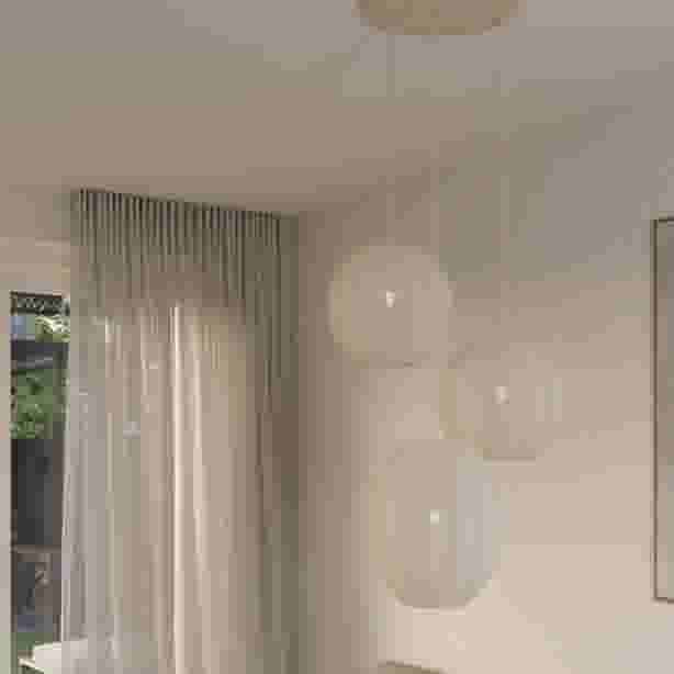 Hanglamp met drie ronde witte stoffen bollampenkappen aan een plafondplaat