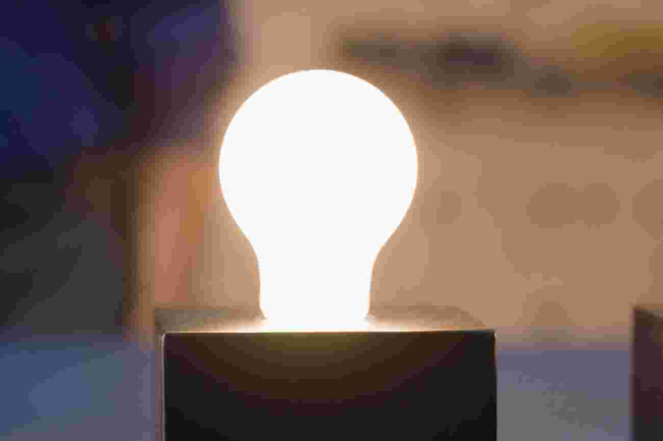 Een brandende LED lamp met peer vorm tegen een onscherpe achtergrond.