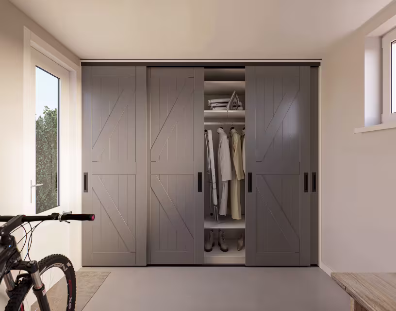Moderne grijze schuifdeuren kledingkast met open middensectie met kleding en schoenen, fiets links in lichte kamer