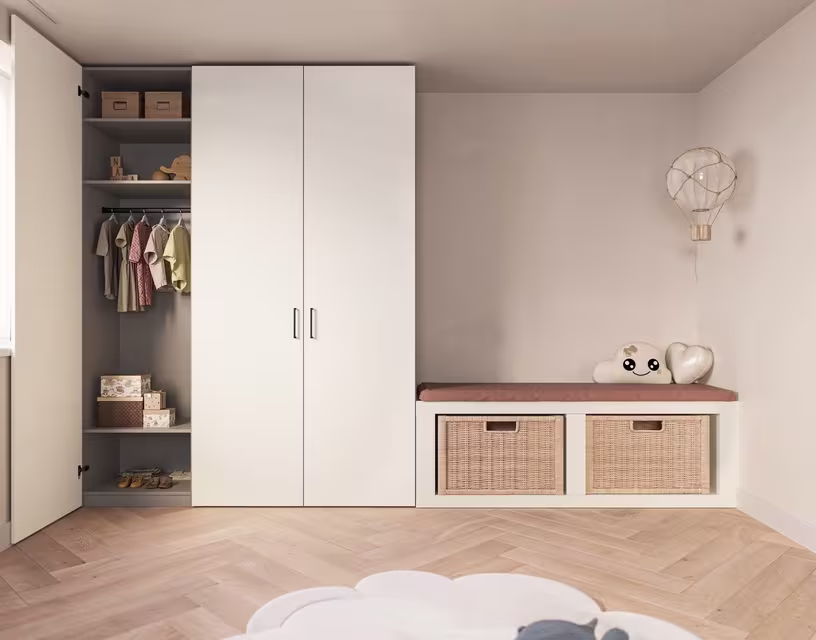 Moderne kinderkamer met witte kledingkast, open planken met kleding, en opbergbank met rieten manden op houten vloer.