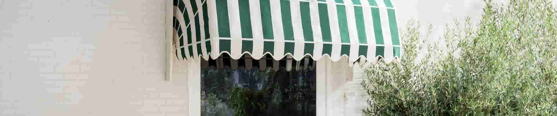 Een markies met witte en groene strepen die is uitgeklapt 