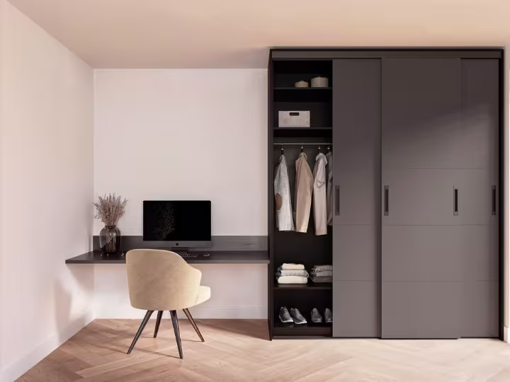 Moderne slaapkamer met zwarte schuifkast, beige bureaustoel, wandbureau en houten visgraatparket