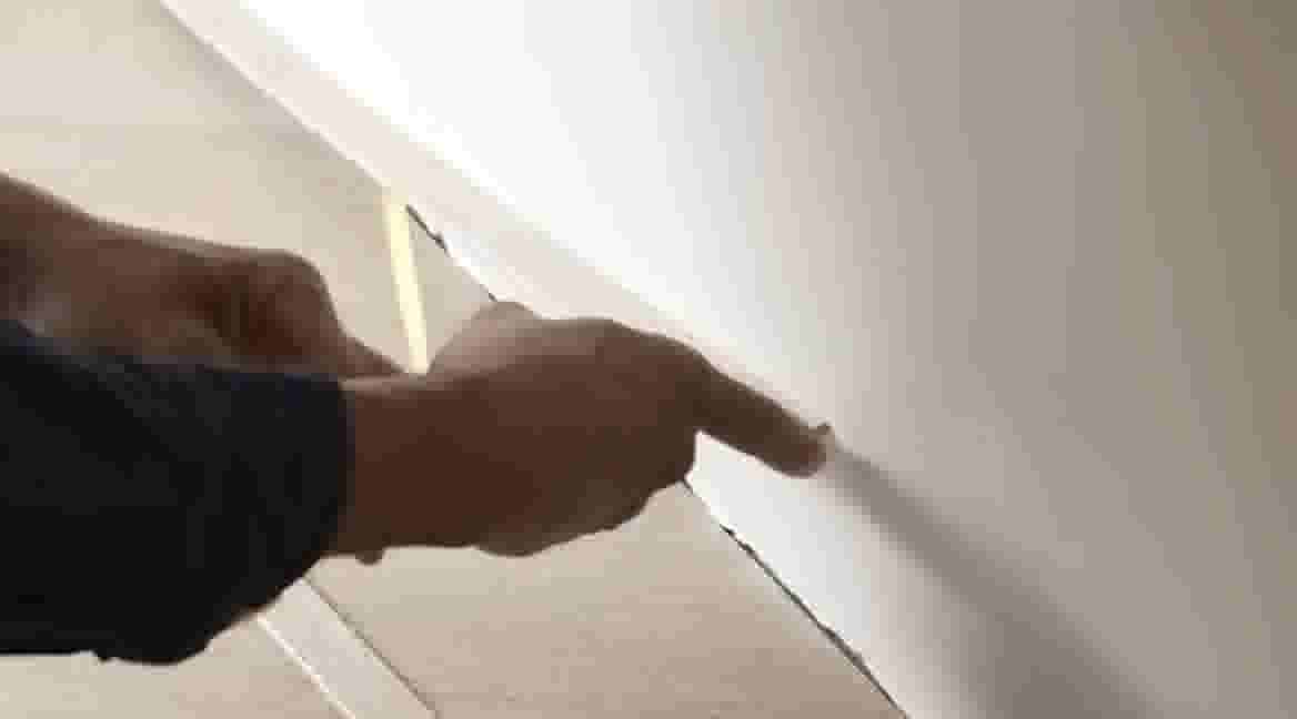 Handen verwijderen het folie van de plakstrip om te bevestigen op de vloer