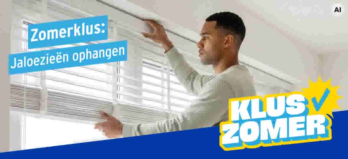 Man hangt witte jaloezieën op aan een raam, met beide handen de rail vasthoudend. Tekst: Zomerklus: Jaloezieën ophangen.