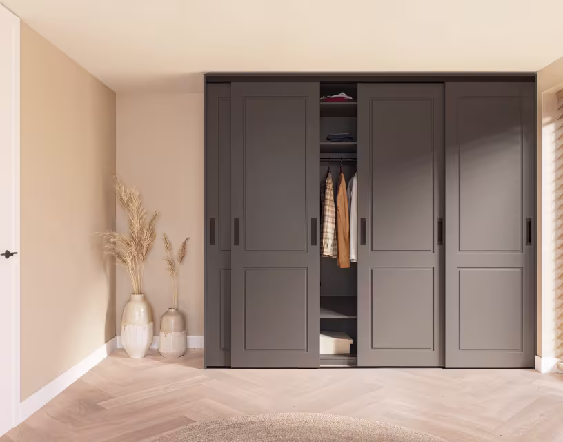 Moderne grijze schuifdeuren kledingkast met open vak met kleding en decoratieve vazen met pampagras ernaast.