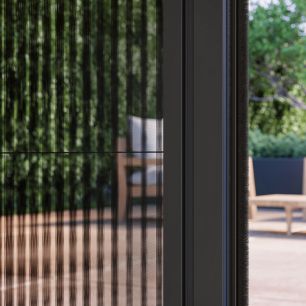 Zwart horrengaas in deuropening met wazig terras met tuinmeubels op de achtergrond