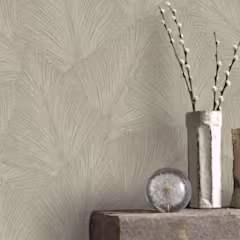 Beige muur met beige vliesbehang met bladpatroon.