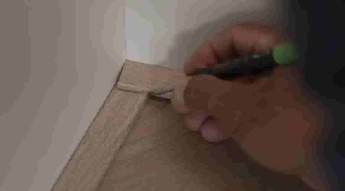 Handen tekenen hoek van plakstrip af door andere plakstrip erop te leggen