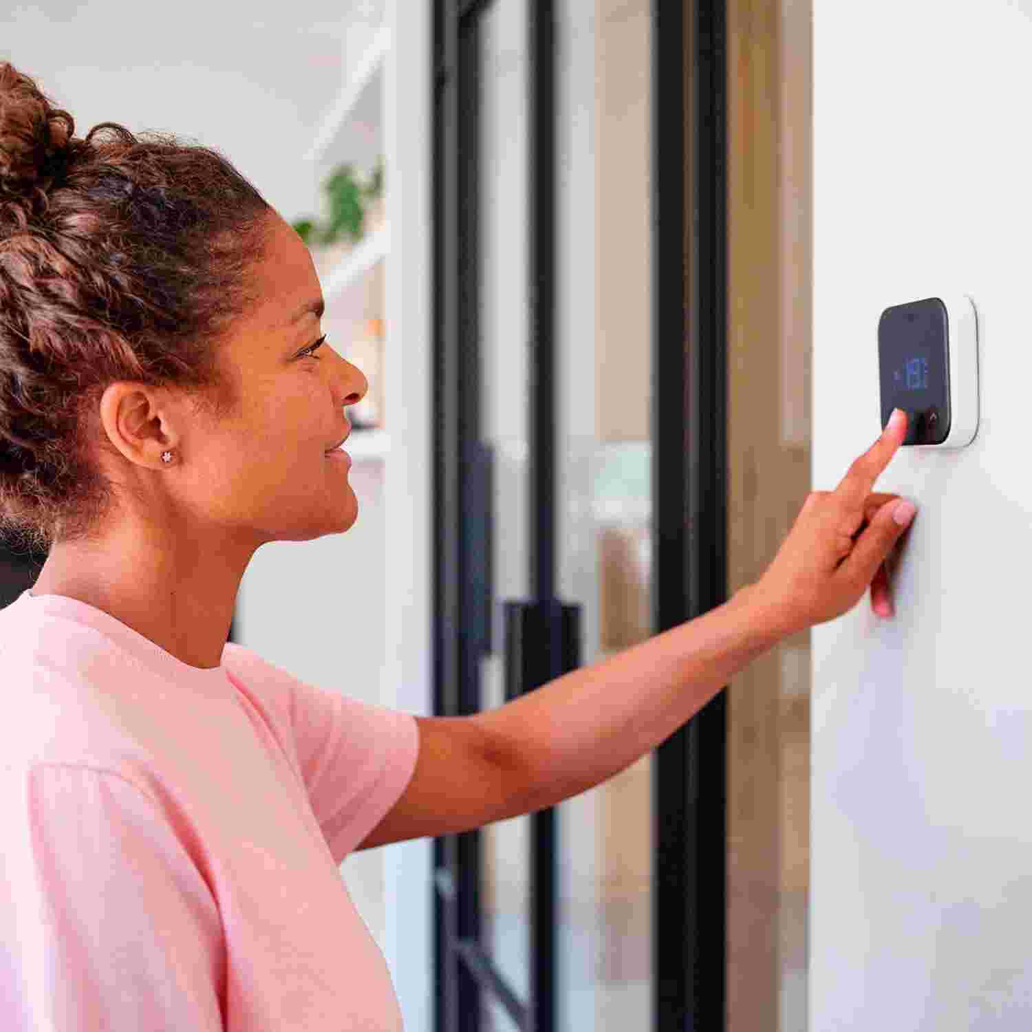 Vrouw bedient een slimme thermostaat