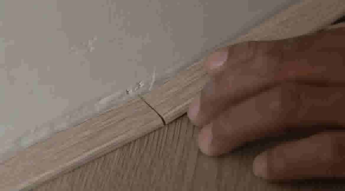 Twee plakstrips stotend aan elkaar bevestigen op de vloer.